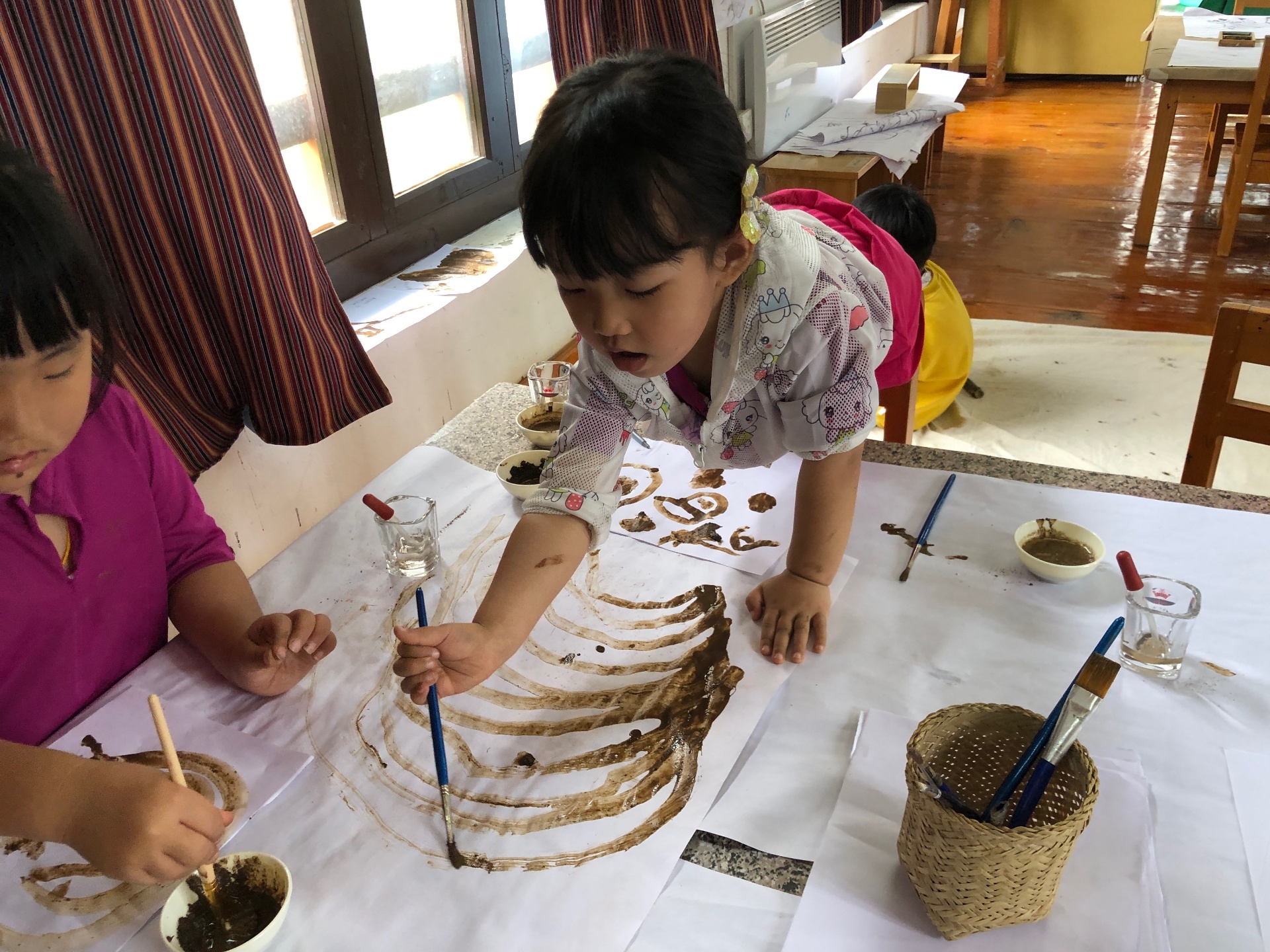Child painting with mud pigments