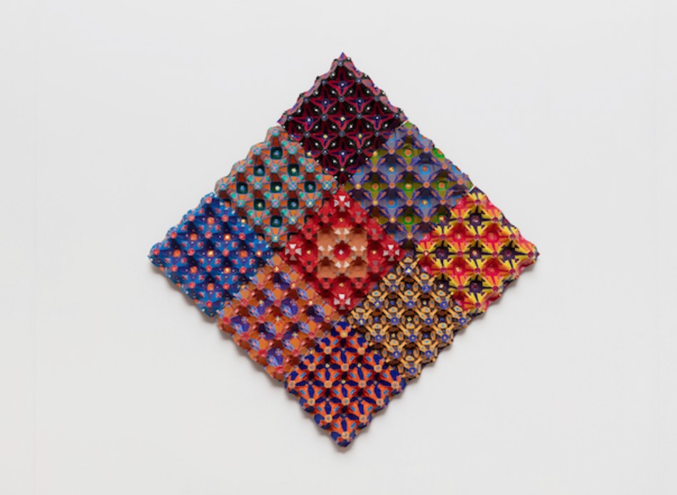 Diamond-shaped wall work composed of colourful patterned egg-carton segments in a grid