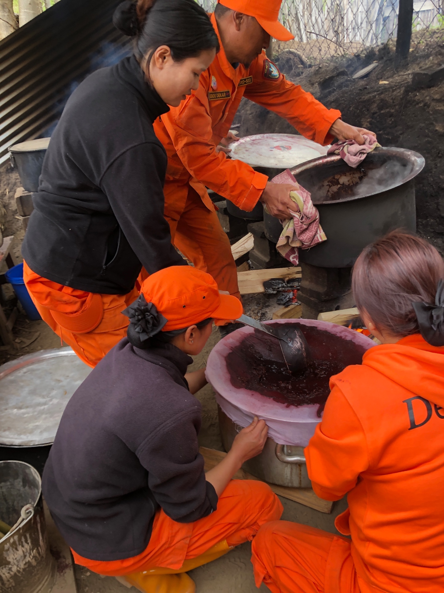 Community members preparing lac dye over a fire in Kencho
